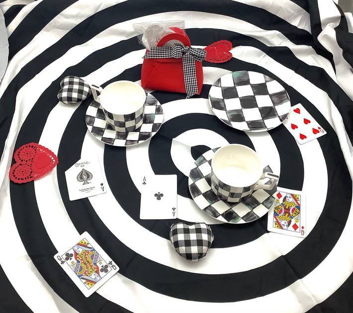 Dukning i Alice i Underlandet-tema med rutiga tekoppar och spelkort.
